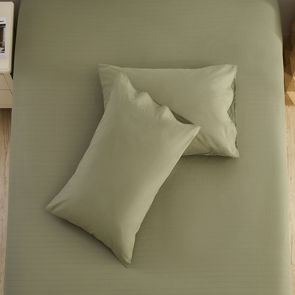 Olive green pillowcases styled in natural light bedroom – organic grounding bedding by Terra Solum